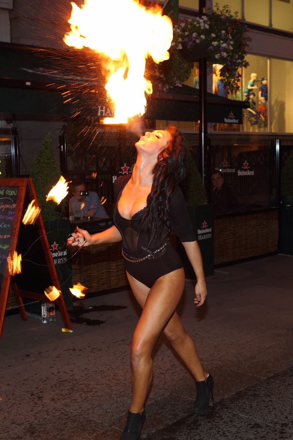 Glamorous fire breather spitting fire into the air, at the launch of Harry's Bar in Dublin, Ireland