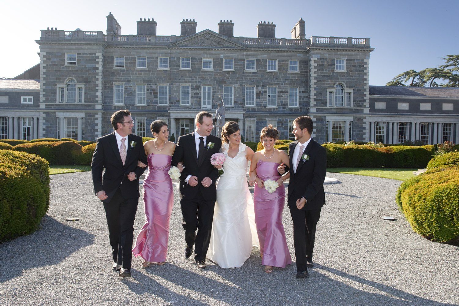 The bridal party walk arm in arm with Carton House as their backdrop