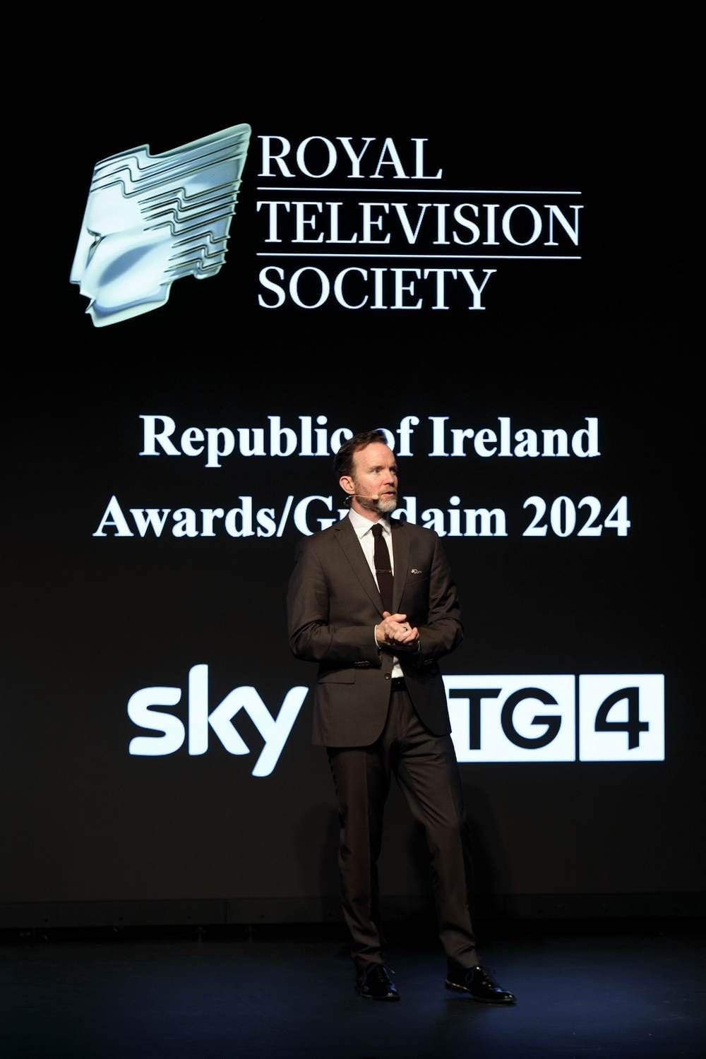 Dermot Whelan is the master of ceremonies pictured in front of the awards backdrop at the 2024 Royal Television Awards held at the Liberty Hall Theatre, Dublin.