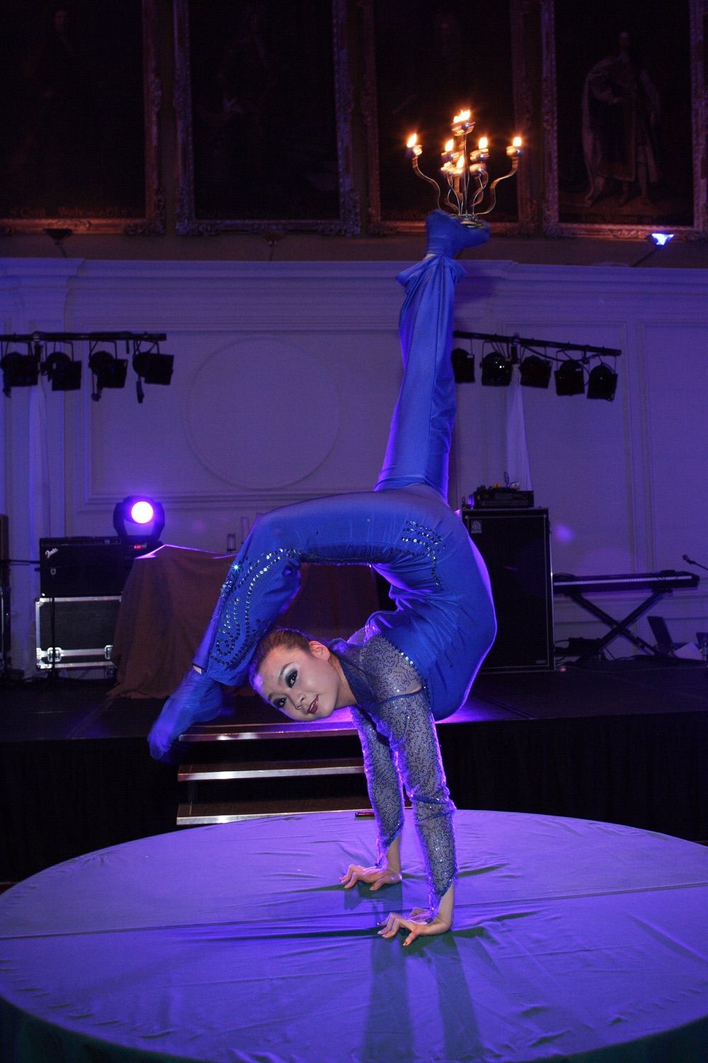 A circus contortionisposes on a table top at a corporate party in the Royal Hospital, Kilmainham