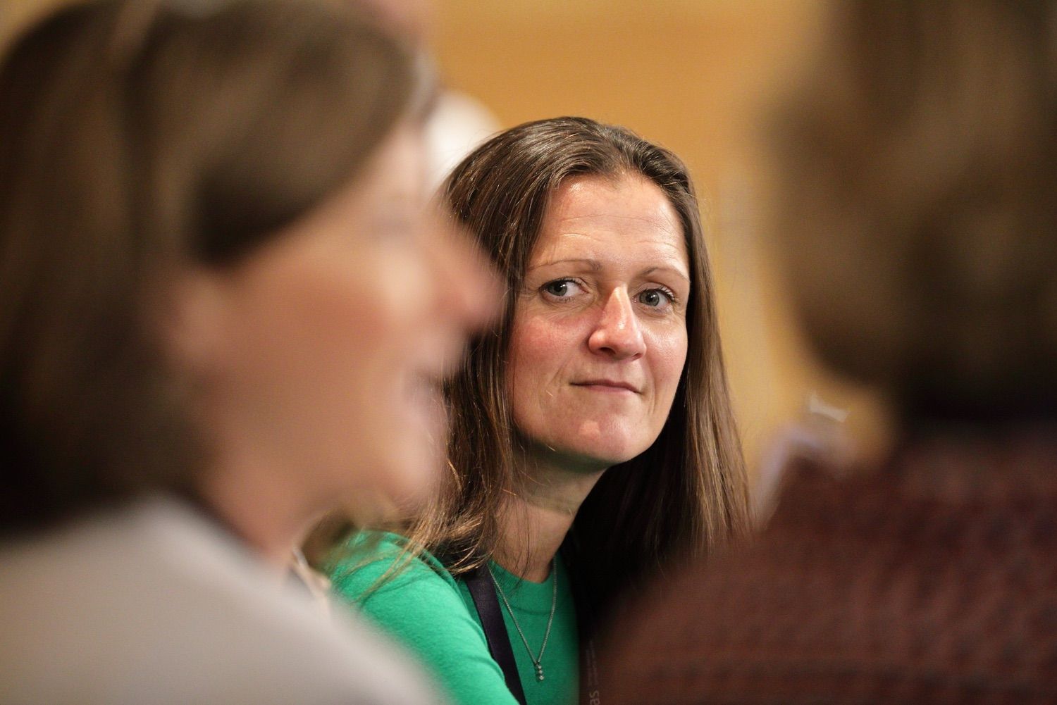 A female delegate photographed through a gab between two other delegates during a discussion time