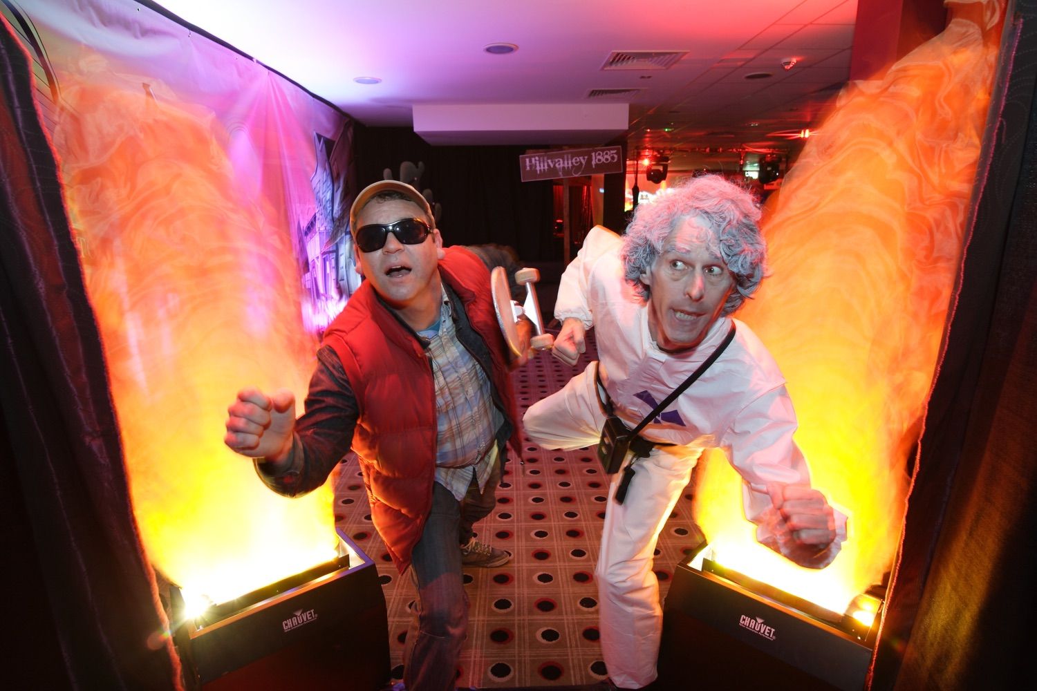 Marty McFly and Doc characters pretend to run at a Back to the Future themed corporate party