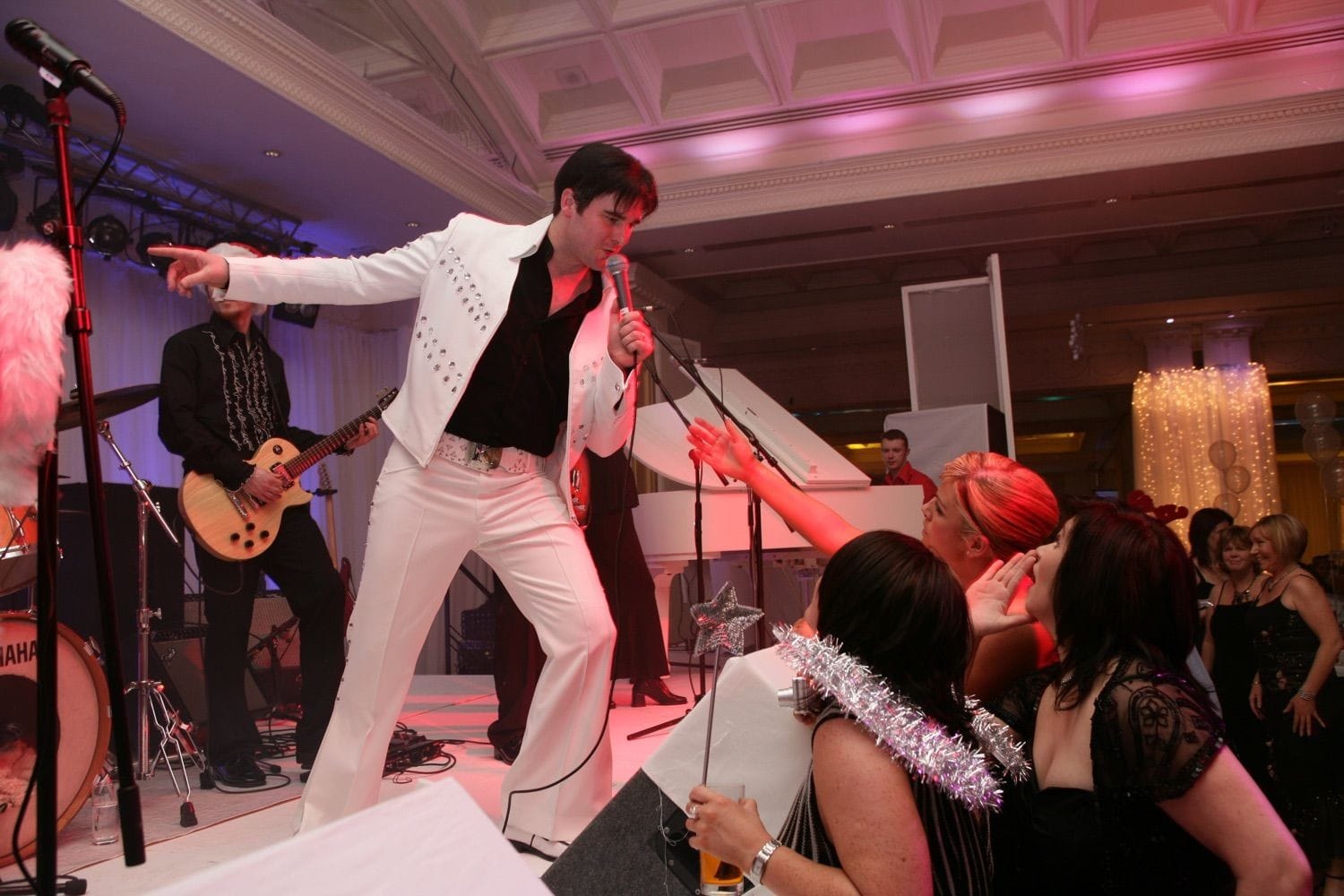 An Elvis impersonatorentertains the ladies at a company party