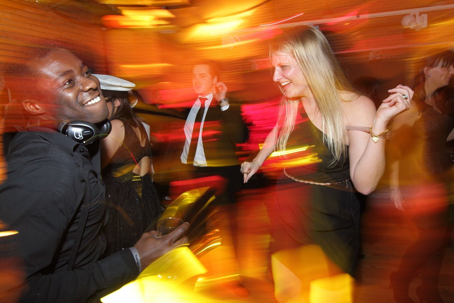 A slow shutter photograph of people danving at a party in the Guinness Storehouse in Dublin