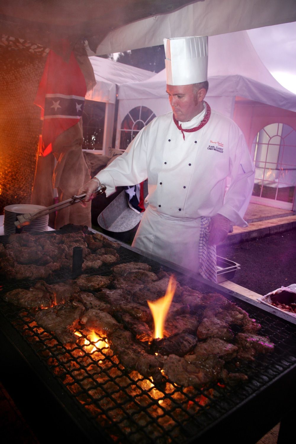 A chef prepares steaks on a big barbeque, for a corporate event at Pembroke Cricket Club in Ballsbridge, Dublin.