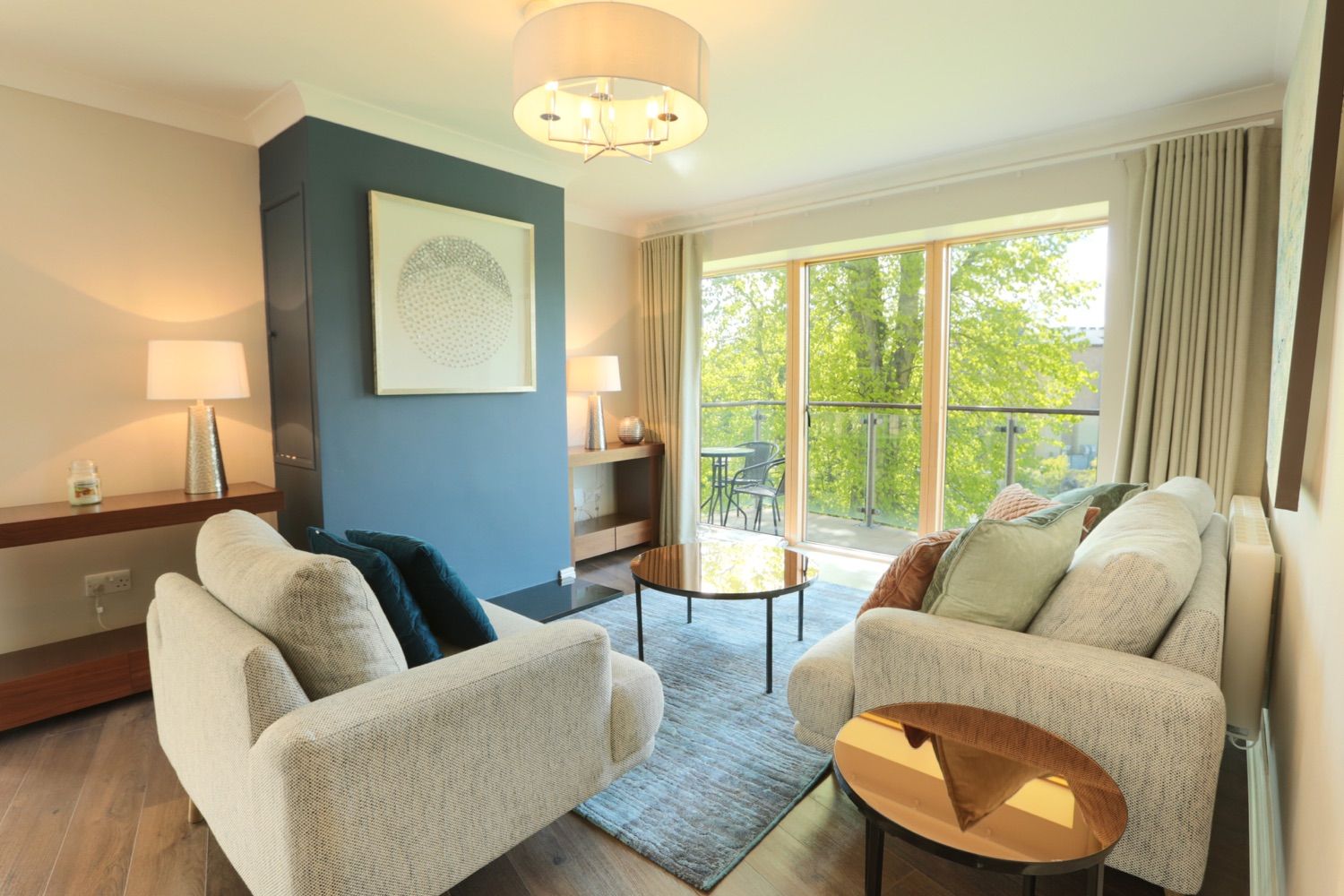 A gorgeous living space with a balcony looking out to the trees and mountains of south Dublin