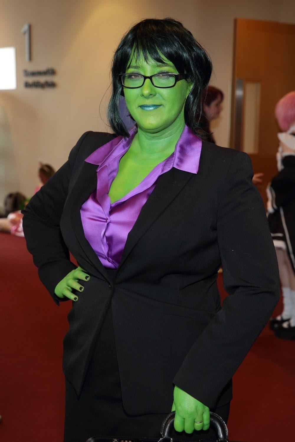 A lady covered in green body paint and dressed in a business suit at Comicon, held in the Conference Centre Dublin