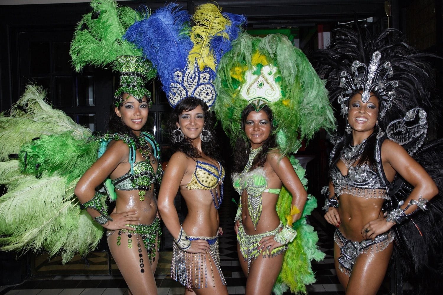 Four carnival girls, dressed in green feathers and sparkles form a welcome party for guests at a corporate party in the Round room at the Mansion House, Dublin