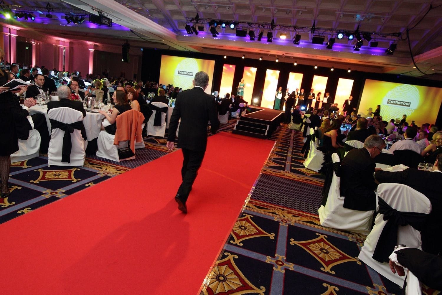 A recipient walks up to the stage to receive his award, at the Deloitte and Touche Business Awards