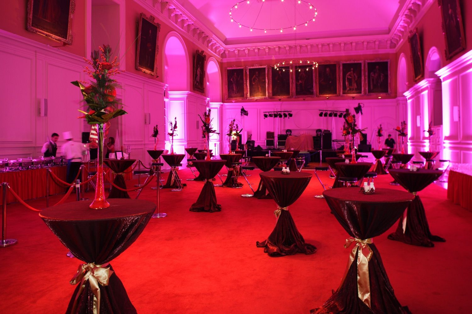 Red carpet, black and gold table linin and pink wall lighting make for a dramatic mood at the Royal Hospital, Kilmainham