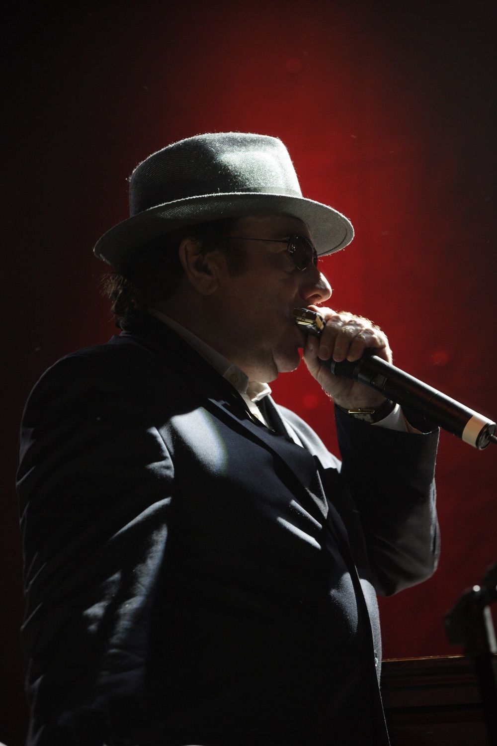 Van Morrison onstage playing a harmonica at a private event in the RDS, Dublin