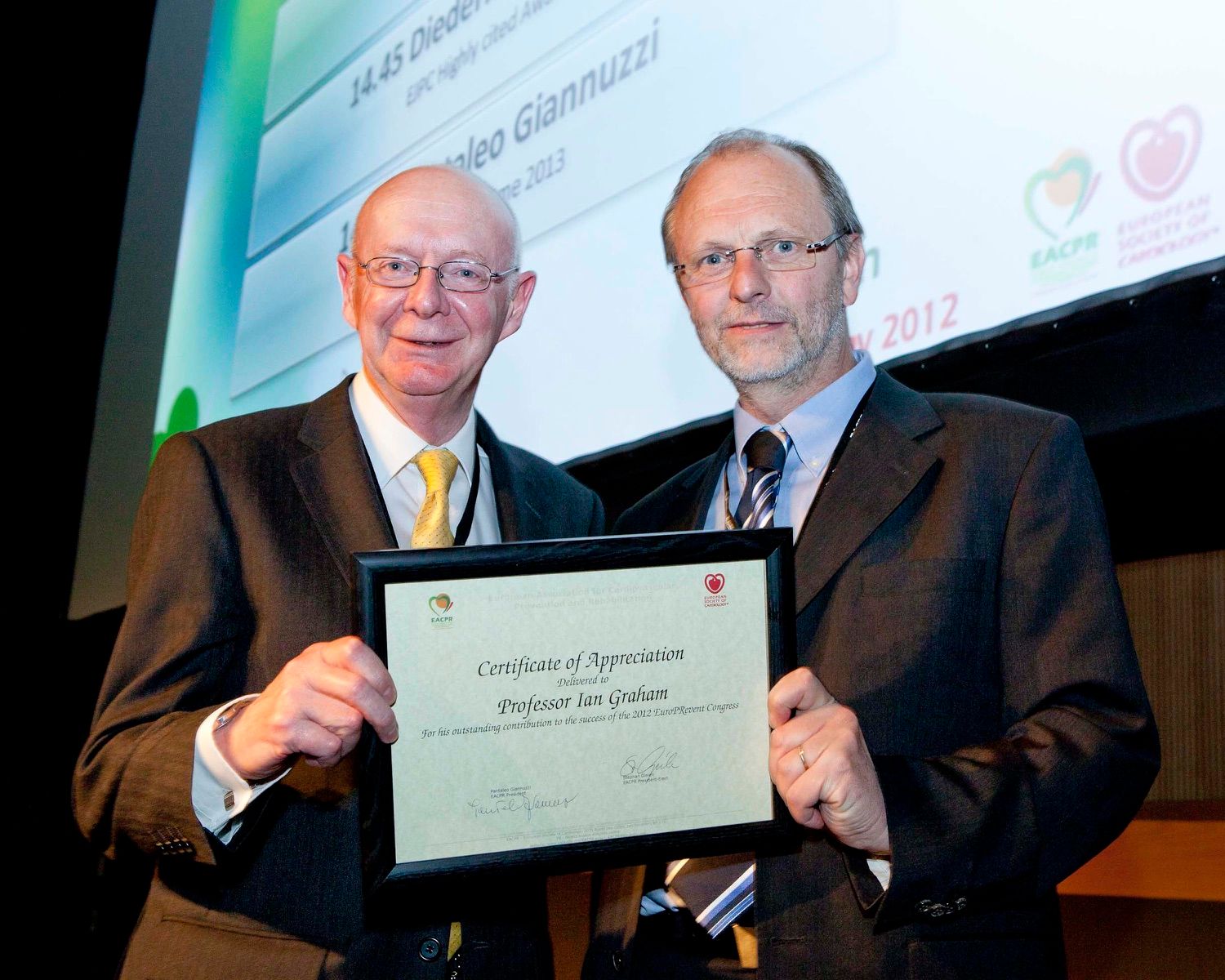 A speaker is presented with an achievement award at a conference in the Convention Centre Dublin