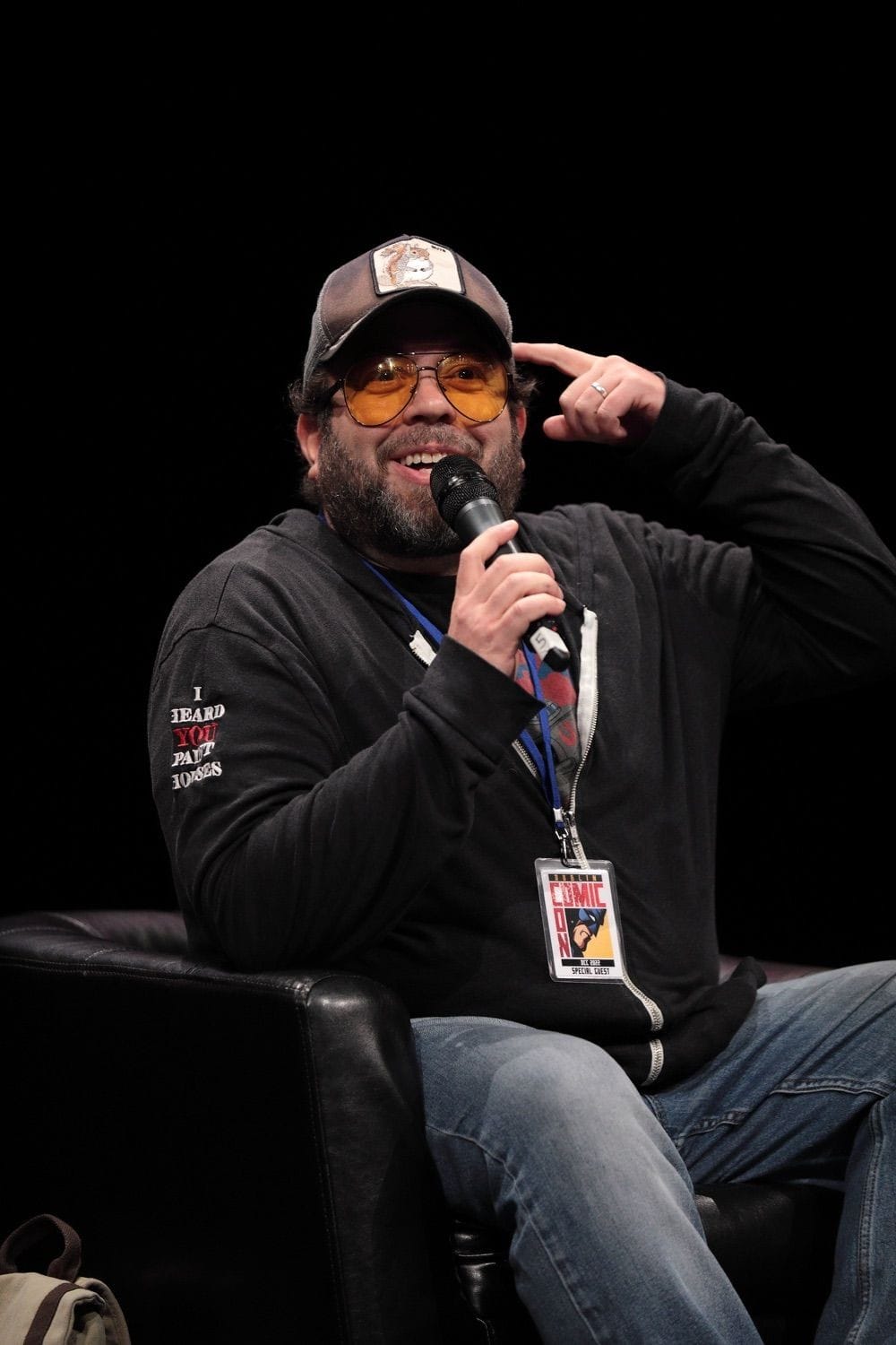 One of the guest speakers at Comicon Dublin, smiles at the audience while holding his finger up to the side of his head at the Conference Centre Dublin