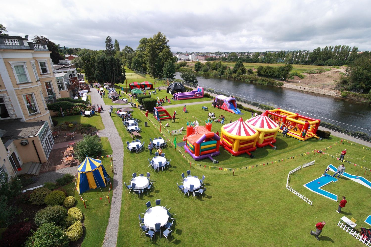 A photograph of the inflatable bouncy castles and entertainment booths set up for a company family fun day