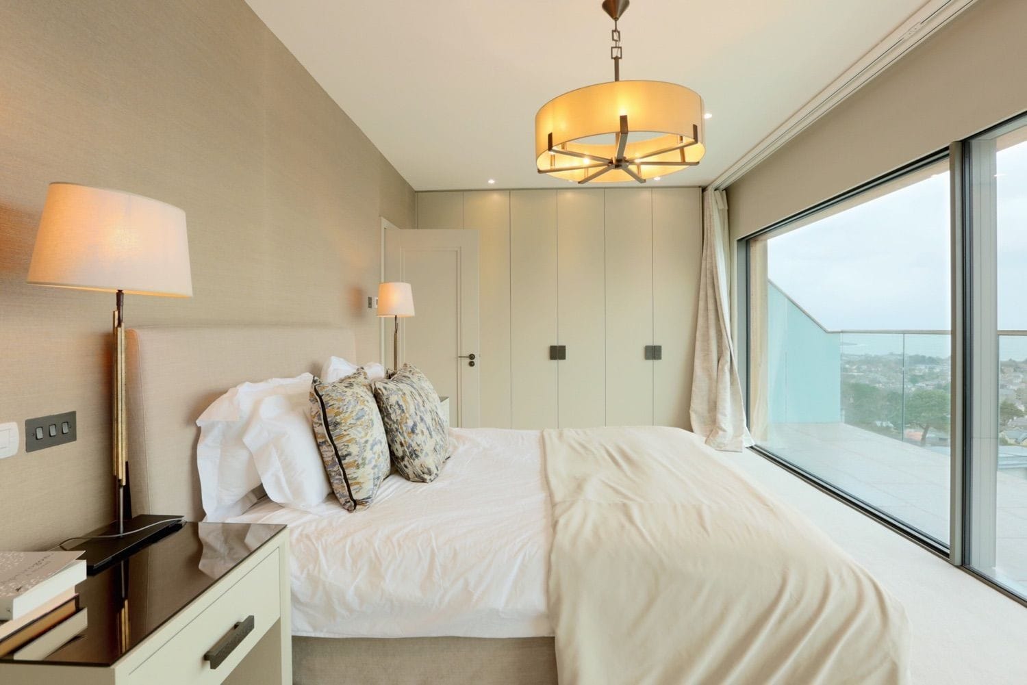 The master bedroom with a panoramic view and balcony looking out over Dublin Bay